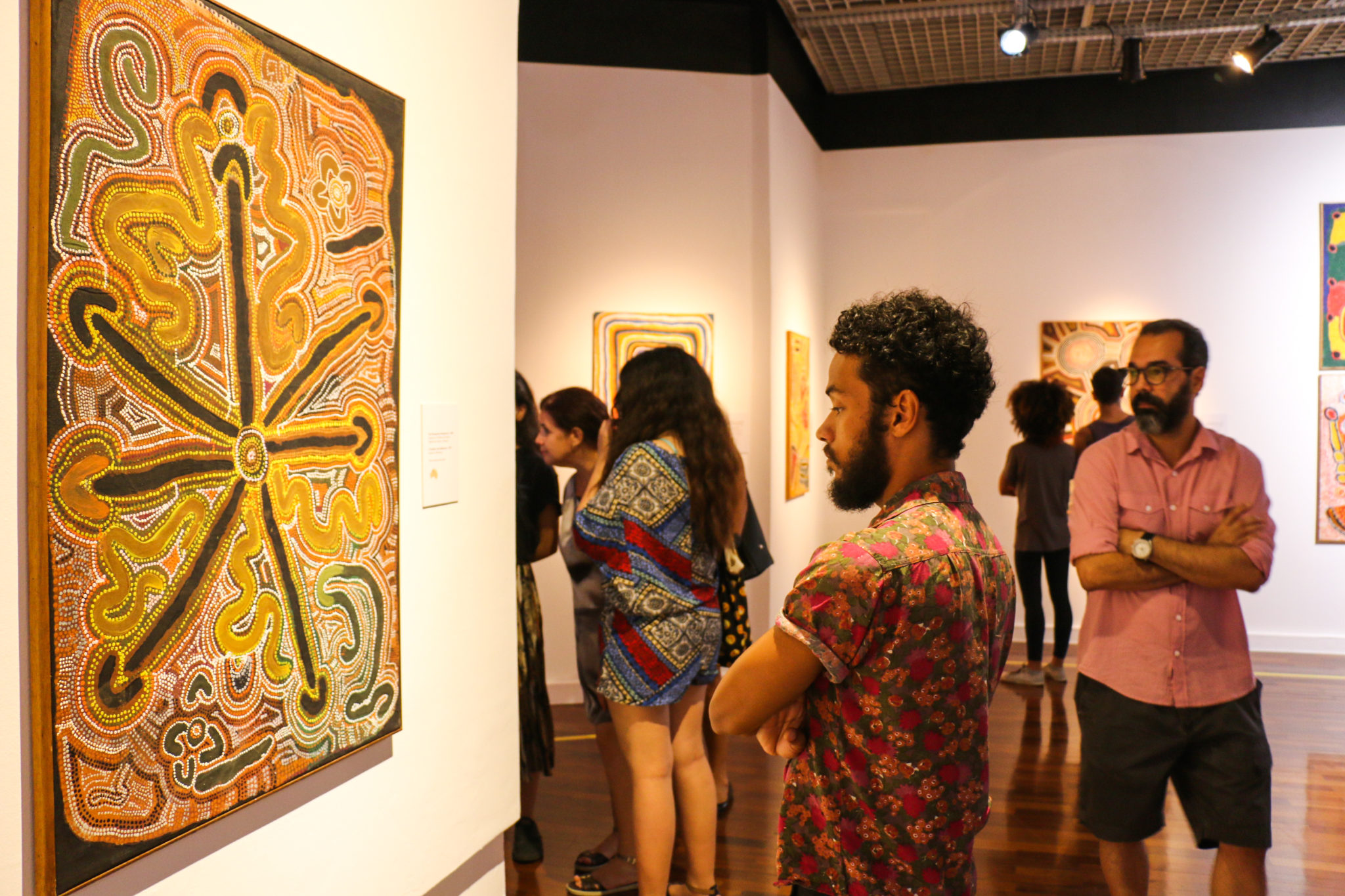 Observador aprecia a obra de uma artista aborígene. Fotografia_ Emmanuelle Bernard.